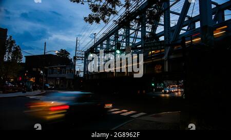 NORWALK, CT, USA-17 LUGLIO 2021: Luci serali sulla trafficata Washington Street in centro con ponte ferroviario Foto Stock