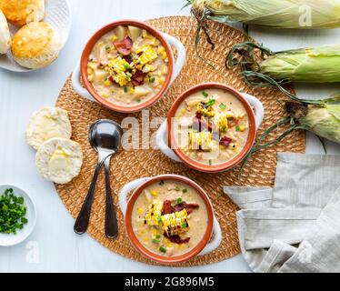 Vista dall'alto della zuppa di pollo e mais con zuppe di crostini ricoperte di mais e pancetta alla griglia, pronti per mangiare. Foto Stock