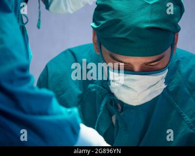 Il ritratto dei chirurghi si concentra sui pazienti in funzione nella sala operatoria dell'ospedale. Foto Stock