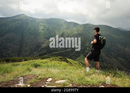 L'atleta in una t-shirt nera si pone sulla cima del monte Mala fatra. Arrampicata Monte Hromova. Un escursionista cammina lungo le creste di Lesser Fatra nello Slov Foto Stock