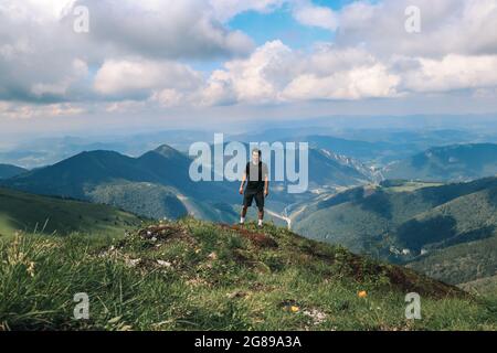 L'atleta in una t-shirt nera si pone sulla cima del monte Mala fatra. Arrampicata Monte Hromova. Un escursionista cammina lungo le creste di Lesser Fatra nello Slov Foto Stock