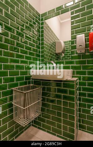 Uno sguardo in uno straordinario bagno ospiti. Con lavandino annesso. Le piccole piastrelle di colore verde scuro sono particolarmente evidenti Foto Stock
