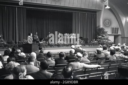 1960, storico, in una grande sala conferenze, Signore e signori membri di club o circoli amatoriali di vino, seduta ad ascoltare una guest speaker femminile in un simposio del corpo amatoriale di vinificazione, la National Association of Wine and Beermakers (NAWB), Bournemouth, Inghilterra, UK. Foto Stock