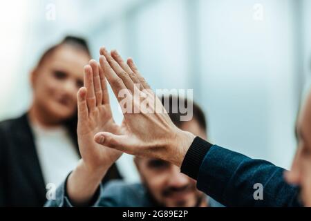 primo piano. giovani dipendenti che si danno a vicenda un alto cinque Foto Stock