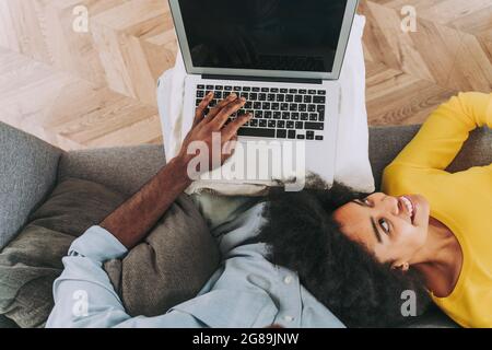 Bella coppia afro-americana che lavora su computer portatile dispositivo - coppia moderna shopping online Foto Stock