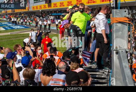 Silverstone Circuit, Silverstone, Northamptonshire, Regno Unito. 18 luglio 2021. Formula uno Gran Premio di Gran Bretagna, Race Day; il pilota del team di F1 Mercedes AMG Petronas Lewis Hamilton salta sopra il muro dei box per festeggiare la sua vittoria con il suo team Credit: Action Plus Sports/Alamy Live News Foto Stock