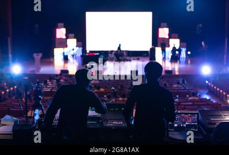 Immagine sfocata del team di tecnici del suono che lavora per preparare il palco del concerto musicale. Foto Stock