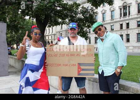 Londra, Regno Unito. 18 luglio 2021. I manifestanti posano per foto con un cartello di protesta in solidarietà con il popolo cubano.migliaia a Londra partecipano ad una manifestazione di solidarietà con il popolo cubano. La protesta cubana, la più grande dalla rivoluzione del 1959, è iniziata una settimana fa in una città alla periferia di l'Avana. I manifestanti hanno invocato la libertà, l'azione per la grave carenza di cibo e medicine. Credit: SOPA Images Limited/Alamy Live News Foto Stock