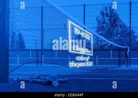 primo piano due racchette da tennis e una palla a terra vicino alla rete sul campo da tennis, colore della tendenza 2020 anni, classici toni blu Foto Stock