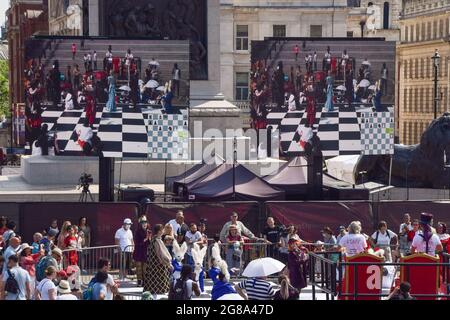 Londra, Regno Unito. 18 luglio 2021. Artisti vestiti da personaggi di Alice attraverso il vetro che guarda giocare a scacchi di dimensioni umane al Chess Fest in Trafalgar Square, un evento gratuito per famiglie che celebra il gioco e il suo fascino duraturo e universale. (Credit: Vuk Valcic / Alamy Live News) Foto Stock