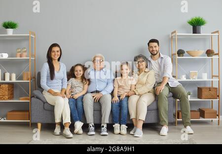 Ritratto di felice famiglia multi-generazionale seduta tutti insieme sul divano a casa Foto Stock