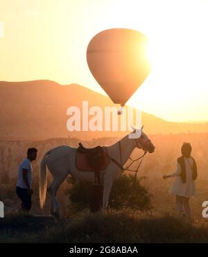 Cappadocia, Turchia. 18 luglio 2021. I turisti sono visti come una mongolfiera vola sopra Cappadocia, Turchia, il 18 luglio 2021. Credit: Mustafa Kaya/Xinhua/Alamy Live News Foto Stock