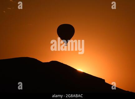 Cappadocia, Turchia. 18 luglio 2021. Il 18 luglio 2021, una mongolfiera si staglia contro il sole sulla Cappadocia, in Turchia. Credit: Mustafa Kaya/Xinhua/Alamy Live News Foto Stock