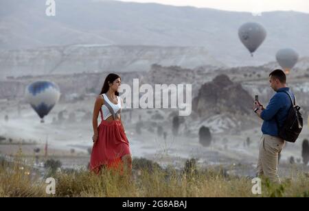 Cappadocia, Turchia. 18 luglio 2021. I turisti sono visti come mongolfiere che sorvolano la Cappadocia, Turchia, il 18 luglio 2021. Credit: Mustafa Kaya/Xinhua/Alamy Live News Foto Stock