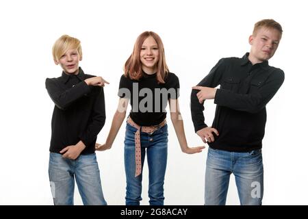 Felice ragazza circondata da fratelli noiosi Foto Stock