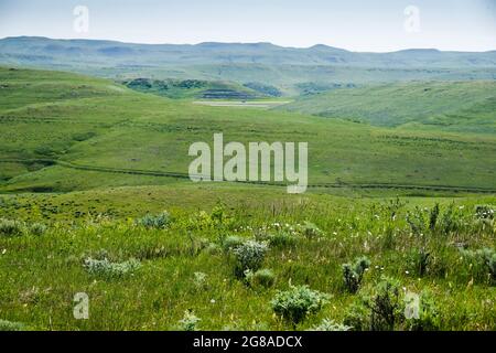 I veicoli percorrono l'Interstate 90 vicino a Story, Wyoming, con i carri del vecchio Bozeman Trail chiaramente visibili sulla collina in mezzo alla distrazione. Foto Stock