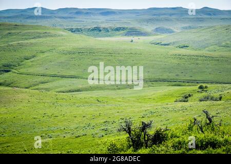 I veicoli percorrono l'Interstate 90 vicino a Story, Wyoming, con i carri del vecchio Bozeman Trail chiaramente visibili sulla collina in mezzo alla distrazione. Foto Stock