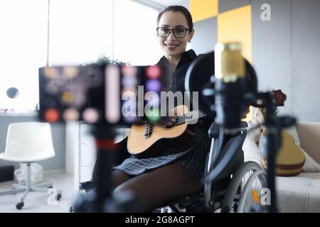 Smiling woman sta registrando un closeup di chitarra Foto Stock