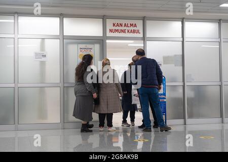 Beyoglu, Istanbul, Turchia - 02.17.2021: Persone in attesa di fronte alla porta della sala di analisi del sangue in Taksim formazione e Ricerca Ospedale in pandemia giorni w Foto Stock