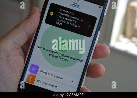 Yeovil, Somerset, Inghilterra, luglio 18 2021: Smartphone con l'app NHS Test and Trace aperta, che mostra le restrizioni Coronavirus rimangono in vigore e l'opzione Foto Stock