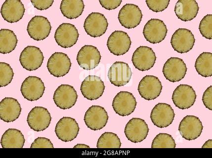 Le fette di ananas disposte casualmente si moltiplicano su sfondo rosa pastello alla moda. Concetto estivo minimo. Foto Stock
