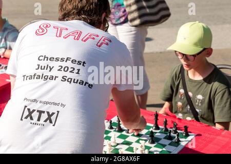 Londra, Regno Unito. 18 luglio 2021. Un membro del personale del Chess Fest ha visto giocare contro un ragazzo. Il Festival degli Scacchi, tenuto da Chess in Schools and Communities (CSC), sostenuto dal Sindaco di Londra e dai mercati XTX, si è svolto il 18 luglio a Trafalgar Square a Londra. Lezioni di scacchi gratuite sono state offerte da insegnanti di scacchi professionisti e dai migliori giocatori britannici, e sono state allestite scacchiere giganti a grandezza naturale su cui giocare. Il festival si è tenuto per promuovere il gioco degli scacchi come un'attività intellettualmente stimolante. Credit: SOPA Images Limited/Alamy Live News Foto Stock