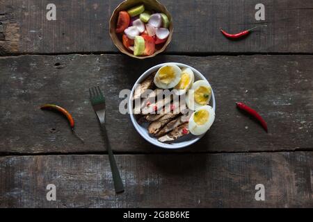 Vista dall'alto del pollo caesar preparato al momento e dell'insalata di uova. Foto Stock