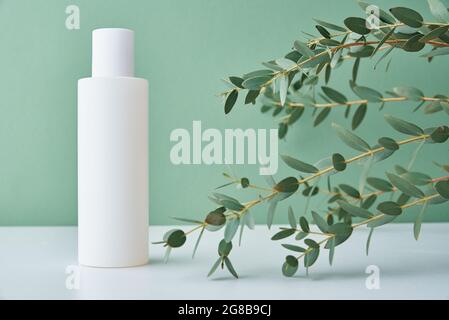 Prodotto cosmetico di bellezza in bottiglia bianca su sfondo verde. Cosmetici naturali biologici Foto Stock