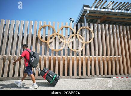 Tokio, Giappone. 19 luglio 2021. Un uomo del Team Mexico cammina attraverso gli anelli olimpici all'ingresso del Villaggio Olimpico. Il Villaggio Olimpico è un complesso residenziale che ospiterà i partecipanti ai Giochi Olimpici del 2020. Le Olimpiadi di Tokyo 2020 si terranno dal 23 luglio 2021 all'8 agosto 2021. Credit: Michael Kappeler/dpa/Alamy Live News Foto Stock