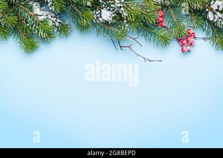 Biglietto d'auguri natalizio con abete coperto di neve su sfondo blu. Vista dall'alto piatto con spazio per la copia dei tuoi saluti natalizi Foto Stock