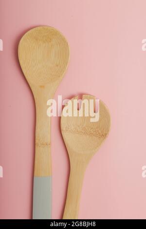 set di cucchiai da cucina in legno su sfondo rosa Foto Stock