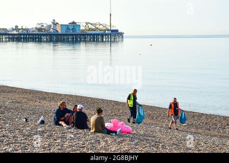 Brighton Regno Unito 19 luglio 2021 - spazzatura sinistra dietro sulla spiaggia di Brighton dopo la folla si è affollato al mare nel tempo caldo durante il fine settimana. Il personale del Consiglio era fuori dalle 5 del mattino per pulire la spiaggia e il lungomare: Credit Simon Dack / Alamy Live News Foto Stock