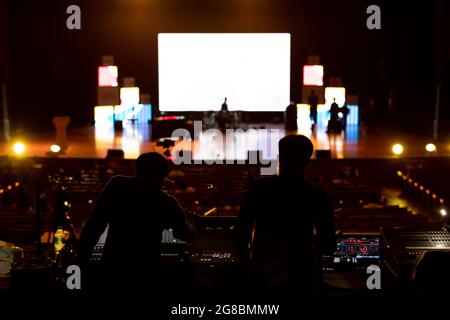 Immagine sfocata del team di tecnici del suono che lavora per preparare il palco del concerto musicale. Foto Stock