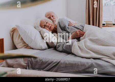 Bella coppia anziana che si gode il tempo insieme a casa - anziani che dormono a letto a casa Foto Stock
