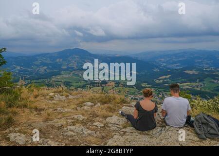 2021 luglio Reggio Emilia: Coppia seduta in montagna e guardando la vista aerea. Escursioni, campeggio, trekking. Coppia insieme Foto Stock