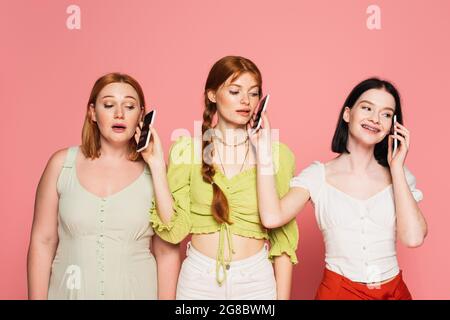 Corpo amici positivi che parlano su smartphone uno vicino l'altro isolato su rosa Foto Stock
