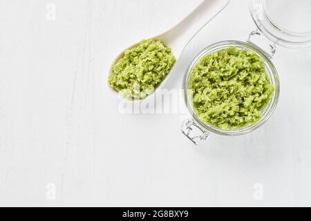 Scrub corpo verde fatto in casa in un vaso di vetro su sfondo bianco. Vista dall'alto, spazio di copia per il testo. Concetto DI SPA. Messa a fuoco selettiva Foto Stock