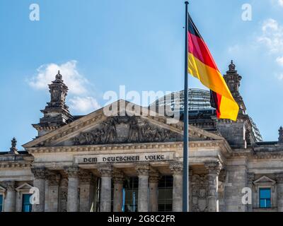 Bella foto di una bandiera tedesca sullo sfondo del palazzo del Reichstag Foto Stock
