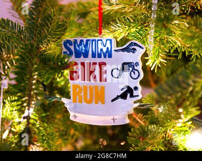 Swim bike eseguire triathlete ornamento di Natale appeso su un albero di Natale. Foto Stock