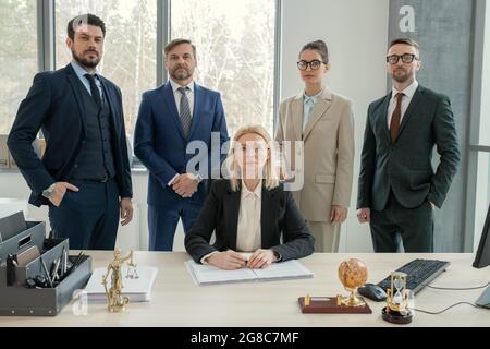 Ritratto del team aziendale di successo con il leader che guarda la fotocamera mentre lavora in team in ufficio Foto Stock