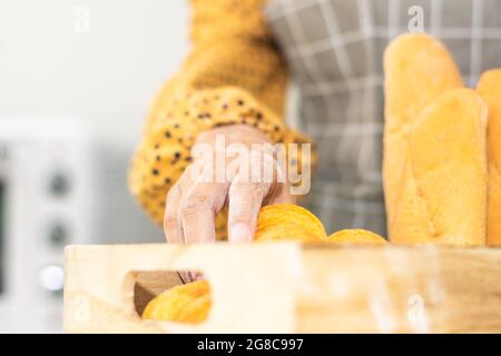 Pane fresco in panetteria per la tenuta delle mani Foto Stock