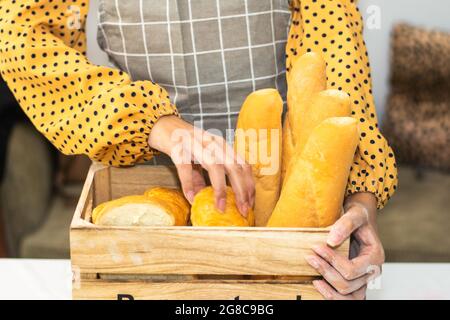 Pane fresco in panetteria per la tenuta delle mani Foto Stock