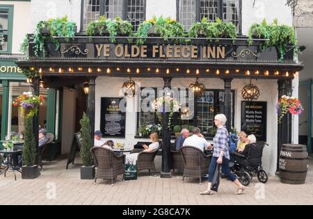 La gente sedette fuori Ye Olde Fleece Inn a Kendal, Cumbria, Inghilterra, Regno Unito Foto Stock
