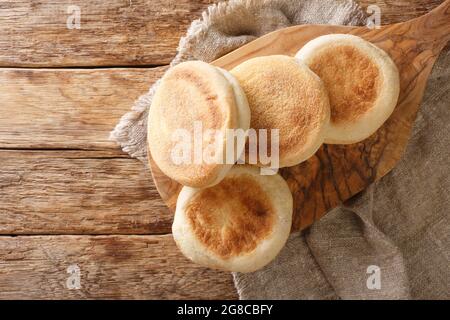 Per una deliziosa colazione, i focaccine inglesi si trovano da vicino su una tavola di legno sul tavolo. Vista orizzontale dall'alto Foto Stock