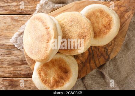 Deliziosi focaccine di muffin inglesi autentici da vicino su un tavolo in legno. Vista dall'alto orizzontale Foto Stock