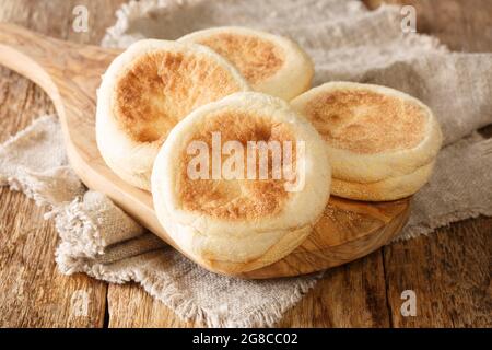 Per una deliziosa colazione, i focaccine inglesi si avvicinano su una tavola di legno sul tavolo. Orizzontale Foto Stock