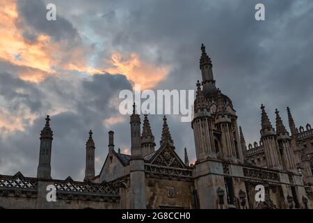 La parte superiore dello schermo e del gatehouse al Kings College, Cambridge al tramonto con un cielo serale drammatico. Foto Stock