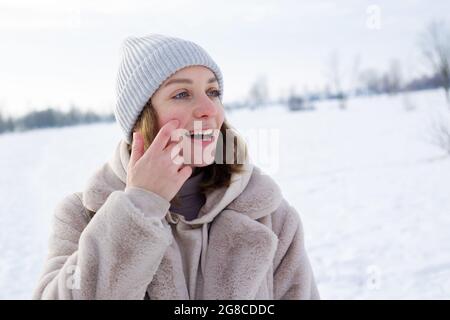 Giovane ragazza in abiti beige, cappotto di pelliccia artificiale passeggiate in inverno Foto Stock