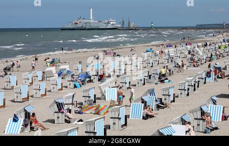 19 luglio 2021, Meclemburgo-Pomerania occidentale, Warnemünde: Molti bagnanti si sono riuniti sulla spiaggia del Mar Baltico. Forti venti e forti correnti hanno portato a un divieto di balneazione, ma non tutti vi aderiscono. Foto: Bernd Wüstneck/dpa-Zentralbild/dpa Foto Stock