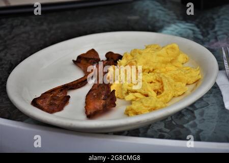 Colazione California molto semplice con 2 uova strapazzate e due pezzi di pancetta fresca Foto Stock